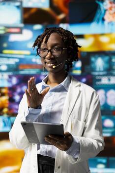 Smiling scientist using tablet to do presentation with xray scans on digital videowall. Jolly woman sharing latest neurology research to audience, using device to project pictures of human organs photo