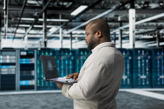 Data center engineer using artificial intelligence automation tools on laptop to increase uptime. Server hub worker working with AI machine learning to accelerate complex AI calculations photo