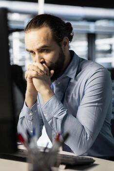 Technician in server room worried after reading diagnostic report showing critical hardware malfunction on PC. Engineer perturbed by error notifications risking network stability and system uptime photo