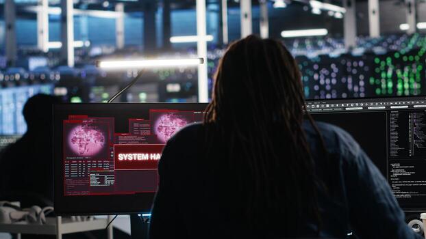 Server hub admin responds to cyberattack attempting to access confidential data while securing hardware systems. Data center worker fighting malware intrusion during security incident, camera B photo