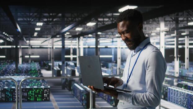 Server hub IT professional managing storage arrays supporting deep learning training workflows. Engineer on industrial platform performing maintenance on servers handling AI processing tasks, photo