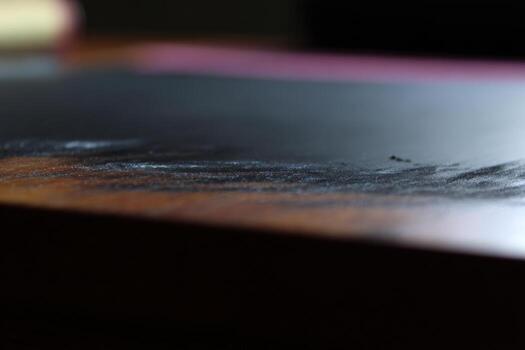 Fading marks and textures on a wooden desk during afternoon light photo
