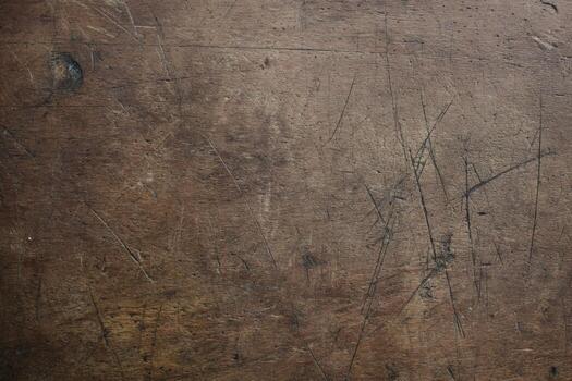 Scratched wooden table surface showing signs of use and age in a casual setting photo