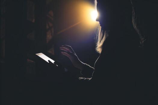 Holding a glowing tablet during a ritual in low light setting photo