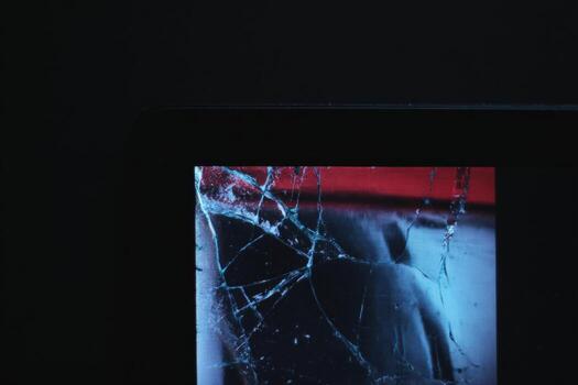 Digital photo frame displaying corrupted image with cracked screen at night