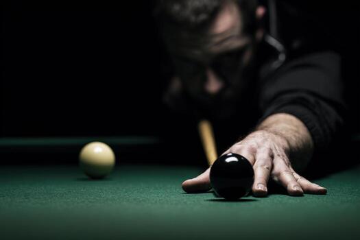 Professional pool player focuses on shot during evening game at local bar photo