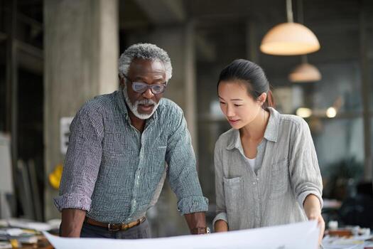 Entrepreneur discusses project plans with young advisor in modern workspace photo