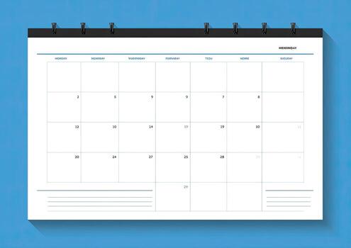 A white calendar sheet showing days of the month on a blue background, with metal fasteners photo