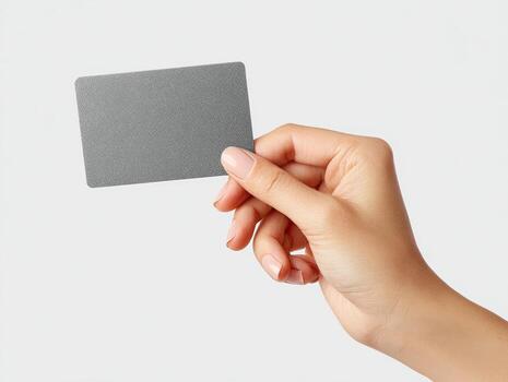 A woman's hand delicately holds a plain, rectangular card against a clean white backdrop photo