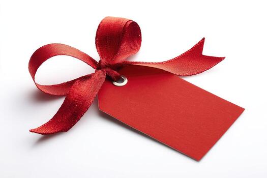 A vibrant red ribbon tied in a bow atop a blank tag, casting a soft shadow photo