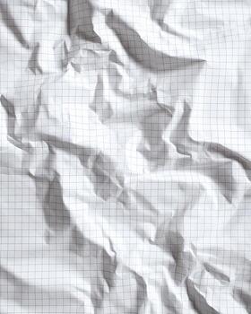 Crinkled graph paper in a vertical orientation, with deep shadows and visible grid lines photo