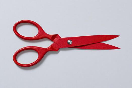 vibrante rojo tijeras en contra un llanura blanco fondo, abierto y Listo a cortar foto