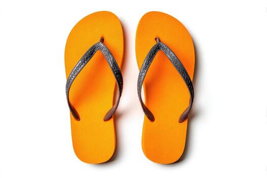 Overhead shot of two bright orange flip-flops with dark gray straps on a white surface photo