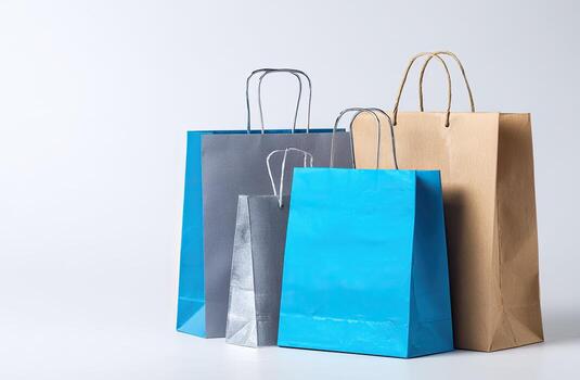 Four colorful shopping bags of varying sizes stand against a plain white background photo