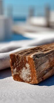 A close-up of a wood block on a tablecloth, blurred background of a beach setting photo