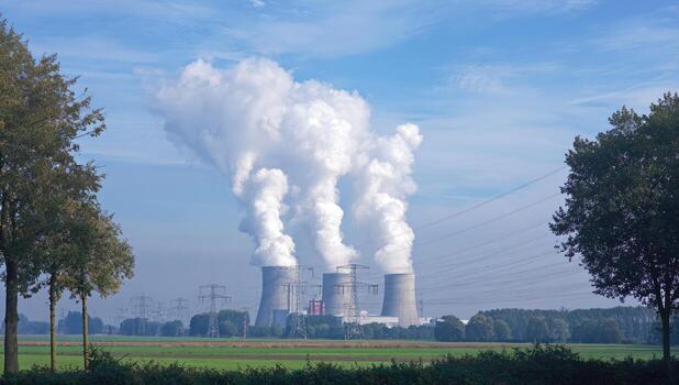 Large industrial complex with multiple cooling towers emitting large plumes of steam, in nature photo