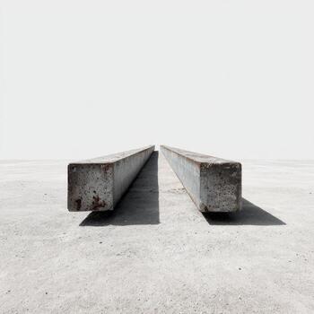 Two parallel, rust-toned metal beams rest on a light-gray concrete surface photo