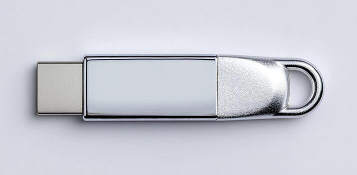 High-angle view of a metallic, rectangular USB flash drive with a loop photo