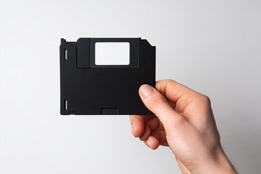 A person holding a floppy disk in their hand photo