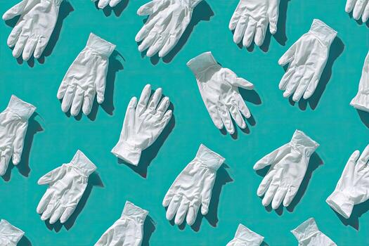 Repeating pattern of white medical gloves against a vibrant teal background with visible shadows photo