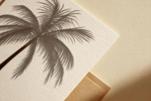 Shadow of a palm tree on textured paper, a flat lay of cards and envelopes photo