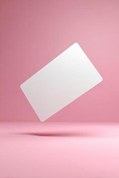 A blank, white rectangular card floats diagonally against a soft pink background photo