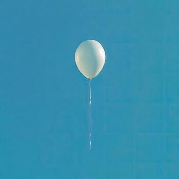 A pale balloon floats in a bright, clear blue sky, tethered by a thin string photo