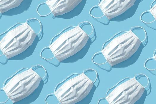 repetido blanco cara mascaras con oído bucles emitir oscuridad en un ligero azul superficie foto