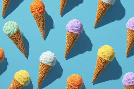 Colorful ice cream cones on a light blue background, arranged in a repeated pattern photo