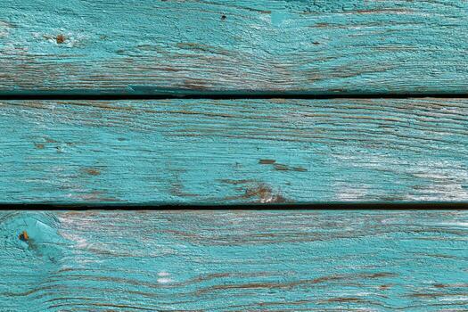 Close-up view of three weathered horizontal wooden planks painted in turquoise photo