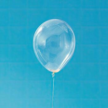 A single clear balloon floats against a bright blue textured background, tethered by a string photo