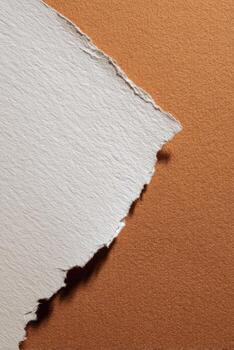 A piece of torn paper on an orange background photo