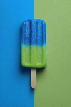 A vibrant popsicle on a stick, split with blue and green tones against a colorful backdrop photo