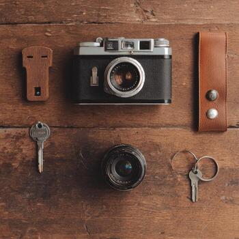 A classic camera sits among various items on a weathered wooden surface, arranged artfully photo