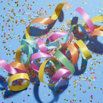 Vibrant streamers and confetti float against a blue background, creating a celebratory feel photo
