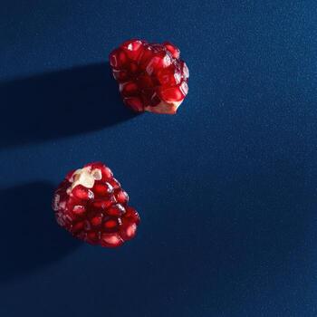 dos secciones de un jugoso, rojo Fruta en un profundo azul antecedentes. fuerte ligero fundición oscuridad foto