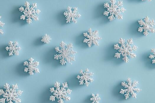 White snowflake ornaments scattered on a soft, light blue background, arranged at various angles photo