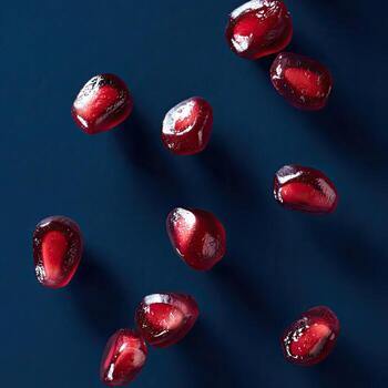 de cerca de granada semillas en un oscuro azul superficie, con oscuridad mejorando profundidad foto