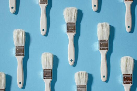 formación de de mango blanco pintar herramientas en un azul superficie, De arriba hacia abajo vista, con ligero y sombra foto