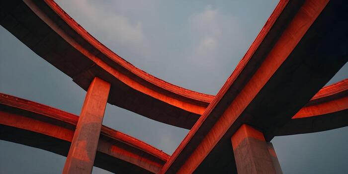Concrete highway overpasses glow with warm sunset light against a muted sky creating a complex geometric pattern photo