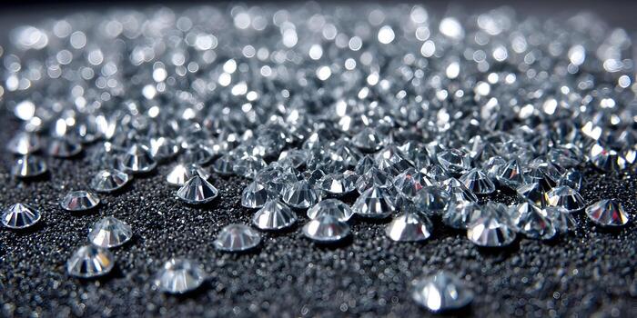 A shimmering close up view of numerous small sparkling rhinestones scattered across a dark textured surface creating a luxurious background photo