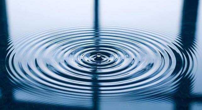 Water drop creating concentric ripples on surface photo