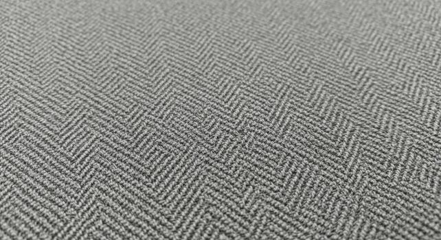 Close up view of a textured gray herringbone weave fabric pattern with subtle light tones photo