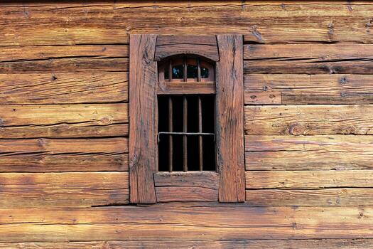 Small barred window in rustic horizontal log wall close up photo