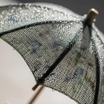 Intricate Close-Up A Surreal Exploration of a Dew-Kissed Miniature Umbrella Bathed in Soft Diffused Light with Exquisite, Curved Fabric Patterns photo