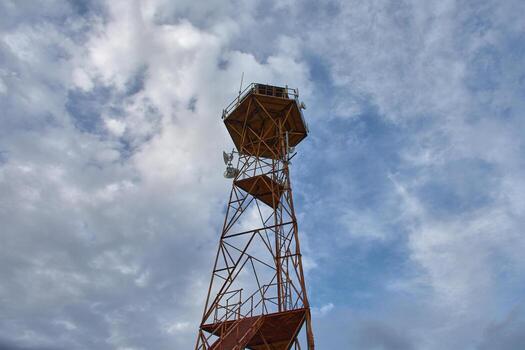 Old observation tower in Pla de la Font transformed into a telecommunications structure against a cloudy background photo