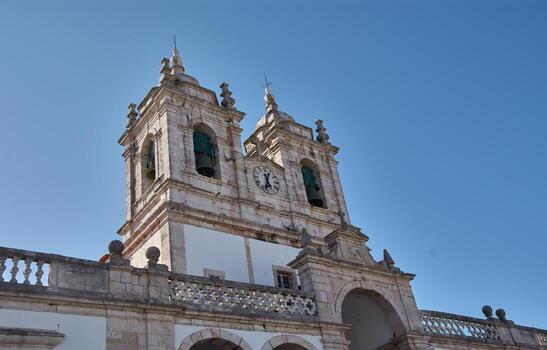 Front view of the Sanctuary of Nazare with Baroque architecture and bell towers on a clear day and in a religious setting photo