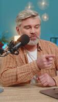 caucasian mogna man bloggare tala in i studio mikrofon interagera med tittare prenumeranter under leva uppkopplad utsända ström vlogg. medelålders kille Sammanträde på Hem tabell gester, respons video