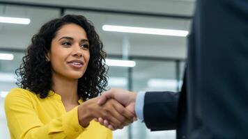A professional interaction takes place in an office setting. Two individuals engage warmly with a handshake and smiles, showcasing a positive atmosphere of collaboration and connection video