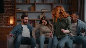 multiethnisch vier freunde Springen Laufen fallen auf Couch beim Zuhause Party geben hoch fünf Lachen lächelnd Vielfalt Gruppe von Beste Freunde Versammlung zusammen Männer Frauen auf Sofa haben Spaß täuschen Einheit video
